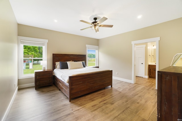 7316 Butt Rd, Fort Wayne, IN 46818 - bedroom with light wood finished floors, multiple windows, ceiling fan, connected bathroom, and recessed lighting