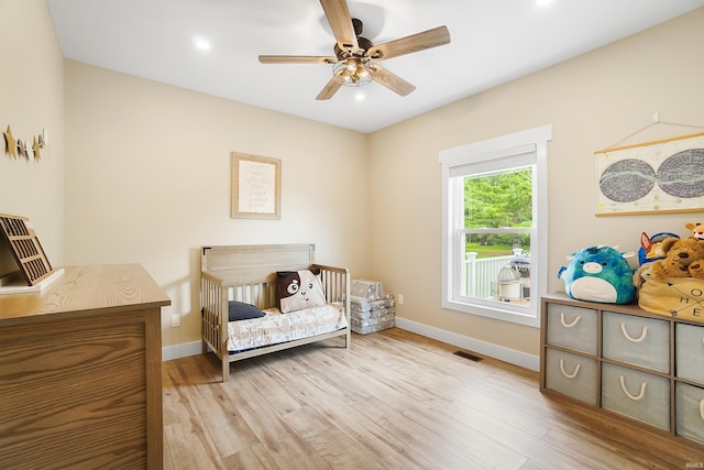 7316 Butt Rd, Fort Wayne, IN 46818 - bedroom with light wood-style flooring, a nursery area, a ceiling fan, and recessed lighting