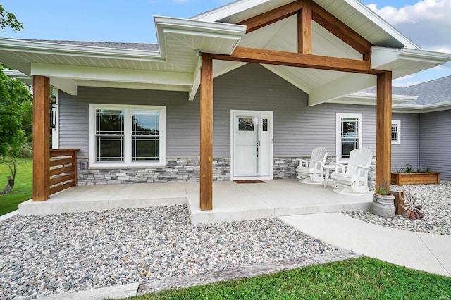 7316 Butt Rd, Fort Wayne, IN 46818 - entrance to property featuring a patio, stone siding, and a shingled roof