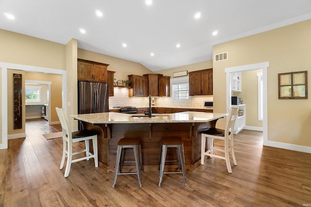 7316 Butt Rd, Fort Wayne, IN 46818 - kitchen with tasteful backsplash, a large island, a kitchen breakfast bar, wood finished floors, and recessed lighting