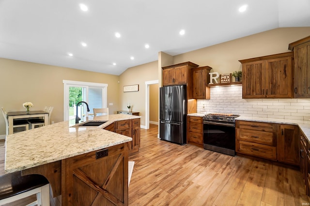 7316 Butt Rd, Fort Wayne, IN 46818 - kitchen with stainless steel appliances, lofted ceiling, light wood-style flooring, a spacious island, and tasteful backsplash