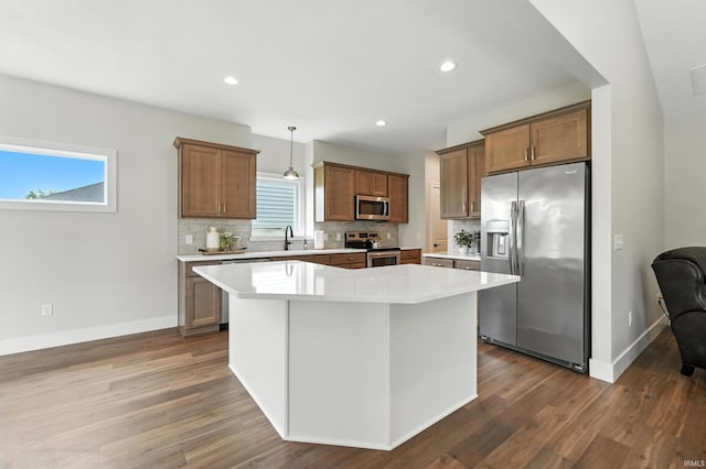 1381 Codorna Cv, Fort Wayne, IN 46804 - kitchen featuring stainless steel appliances, dark wood-style flooring, tasteful backsplash, light countertops, and a kitchen island