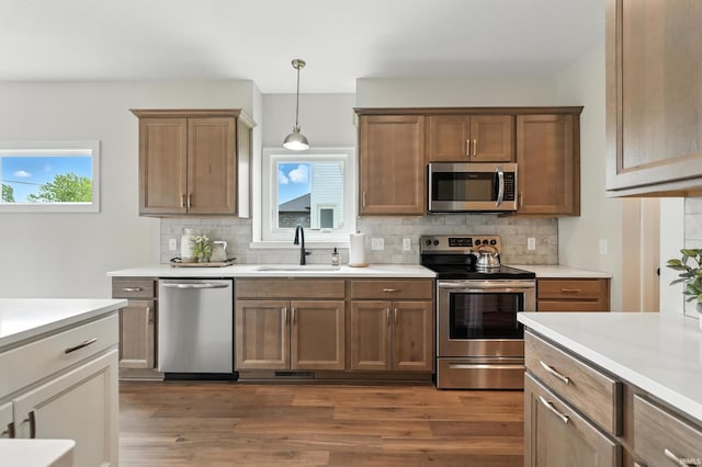 1381 Codorna Cv, Fort Wayne, IN 46804 - kitchen with stainless steel appliances, dark wood finished floors, backsplash, and light countertops