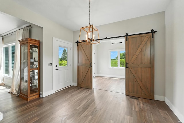 1381 Codorna Cv, Fort Wayne, IN 46804 - foyer with a barn door, wood finished floors, a chandelier, and a wall mounted AC