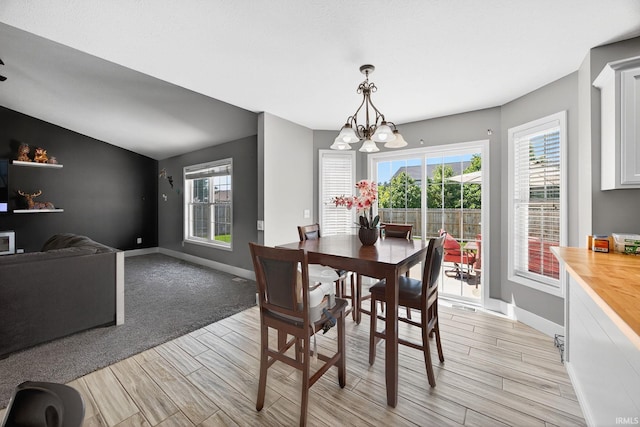 4310 Ashard Dr, South Bend, IN 46628 - dining space featuring wood tiled floors, a chandelier, and healthy amount of natural light