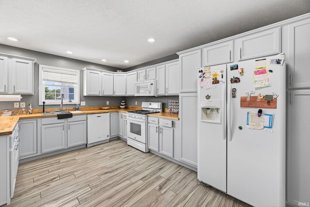 4310 Ashard Dr, South Bend, IN 46628 - kitchen with white appliances, wooden counters, light wood-style floors, recessed lighting, and a textured ceiling