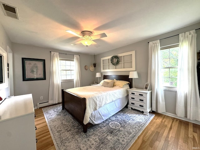 1896 N Michael Dr, Marion, IN 46952 - bedroom with light wood-style flooring, ceiling fan, and a baseboard heating unit