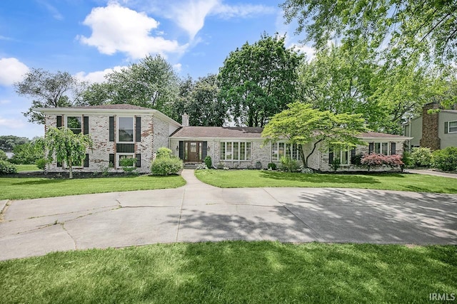 3111 N Eastlake Dr, Elkhart, IN 46514 - split level home featuring a front lawn, a chimney, and brick siding