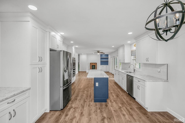3111 N Eastlake Dr, Elkhart, IN 46514 - kitchen with appliances with stainless steel finishes, a ceiling fan, recessed lighting, a brick fireplace, and white cabinetry