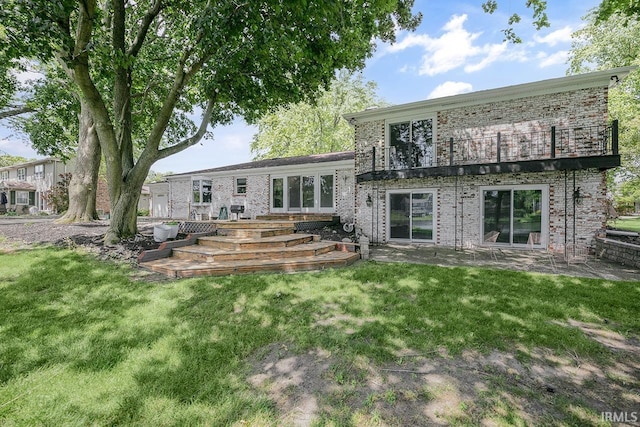 3111 N Eastlake Dr, Elkhart, IN 46514 - back of house with a lawn, a balcony, brick siding, and a patio