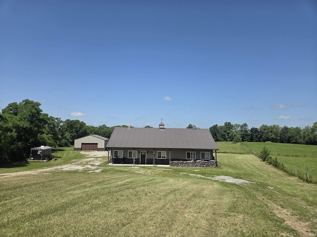 5811W Janssen Ln, Crawfordsville, IN 47933 - view of front facade with a detached garage, a front yard, an outbuilding, a metal roof, and a view of rural / pastoral area