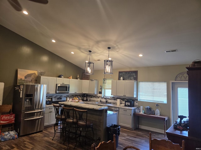 5811W Janssen Ln, Crawfordsville, IN 47933 - kitchen featuring stainless steel appliances, backsplash, dark wood-style flooring, white cabinetry, and a center island