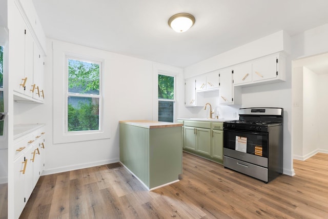 3222 Dinnen Ave, Fort Wayne, IN 46807 - kitchen featuring stainless steel range with gas cooktop, light countertops, light wood-type flooring, and green cabinets