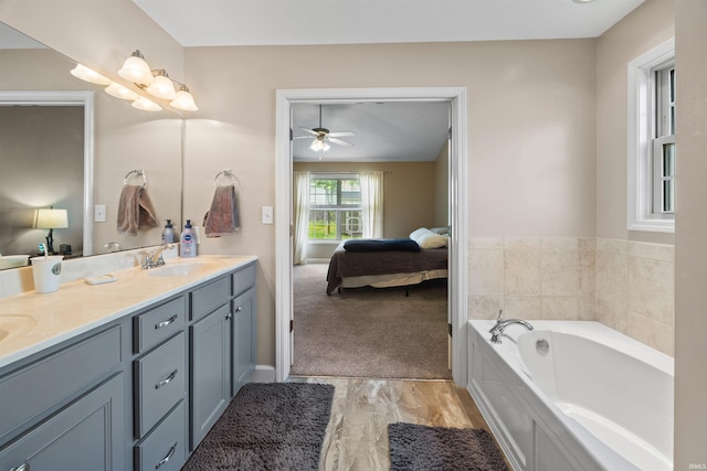 378 Buchanan St, West Lafayette, IN 47906 - ensuite bathroom with double vanity, a bath, a ceiling fan, and wood finished floors
