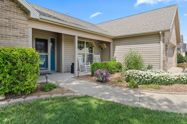 378 Buchanan St, West Lafayette, IN 47906 - view of exterior entry with brick siding, a porch, and a shingled roof