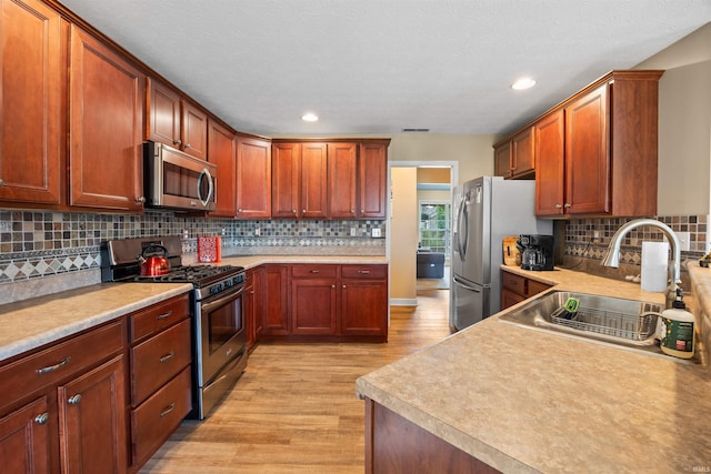 378 Buchanan St, West Lafayette, IN 47906 - kitchen featuring stainless steel appliances, light wood-type flooring, backsplash, light countertops, and recessed lighting