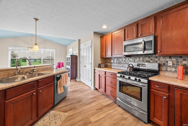 378 Buchanan St, West Lafayette, IN 47906 - kitchen with stainless steel appliances, light wood finished floors, backsplash, lofted ceiling, and hanging light fixtures