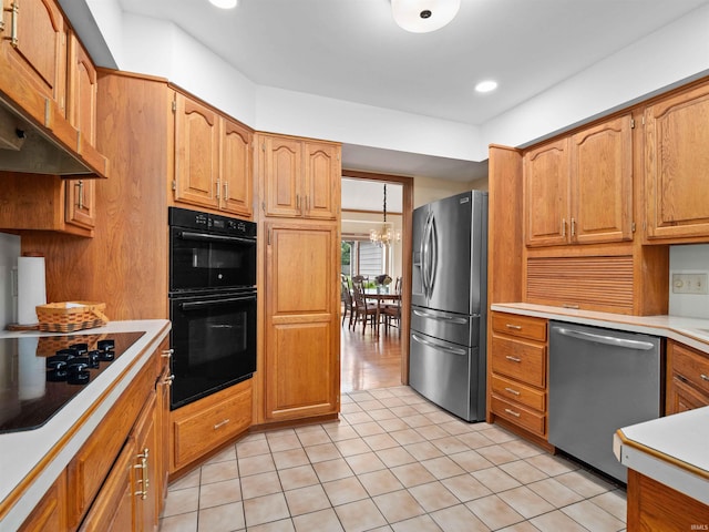 1031 Skyline Pass, Fort Wayne, IN 46825 - kitchen with black appliances, ventilation hood, light countertops, light tile patterned flooring, and a chandelier
