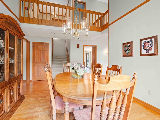 1031 Skyline Pass, Fort Wayne, IN 46825 - dining room with stairs, light wood-type flooring, a chandelier, and a towering ceiling