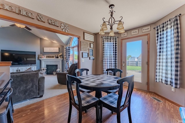 12 Chrysler Ave, Wabash, IN 46992 - dining room featuring a fireplace, lofted ceiling, a ceiling fan, wood finished floors, and a chandelier