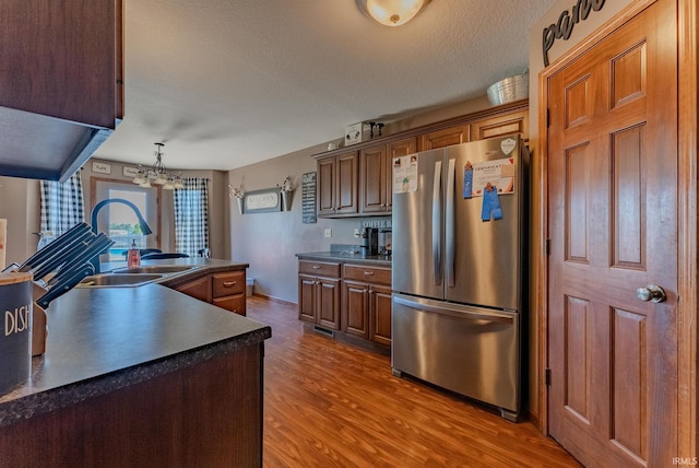 12 Chrysler Ave, Wabash, IN 46992 - kitchen with freestanding refrigerator, dark countertops, wood finished floors, a chandelier, and a textured ceiling