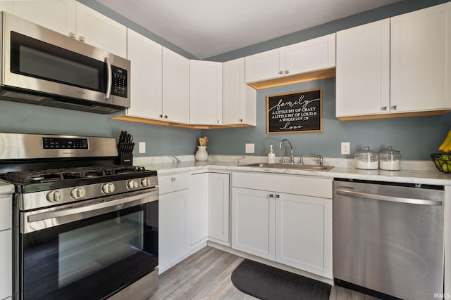 2721 Schumacher Dr, Mishawaka, IN 46545 - kitchen with stainless steel appliances, light countertops, light wood-type flooring, and white cabinetry