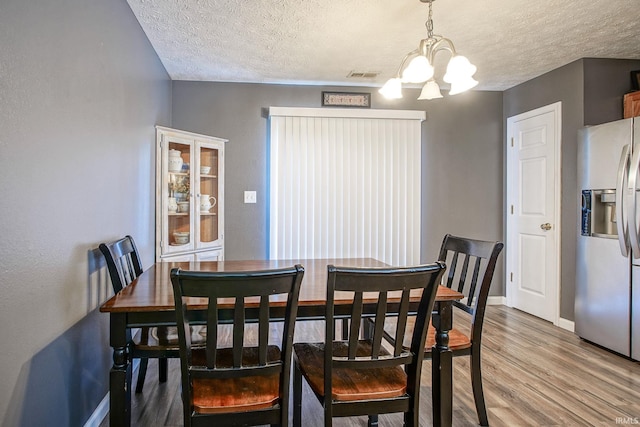 274 Chapelhill Dr, Lafayette, IN 47905 - dining area featuring a chandelier, wood finished floors, and a textured ceiling