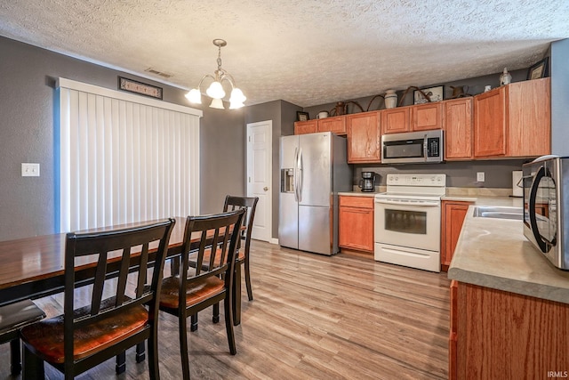 274 Chapelhill Dr, Lafayette, IN 47905 - kitchen with stainless steel appliances, a chandelier, light wood-style flooring, a textured ceiling, and decorative light fixtures