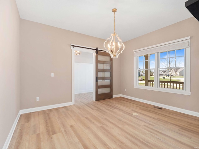 13092 Hallux Cv, Fort Wayne, IN 46845 - unfurnished room featuring a barn door, a chandelier, and light wood-style floors