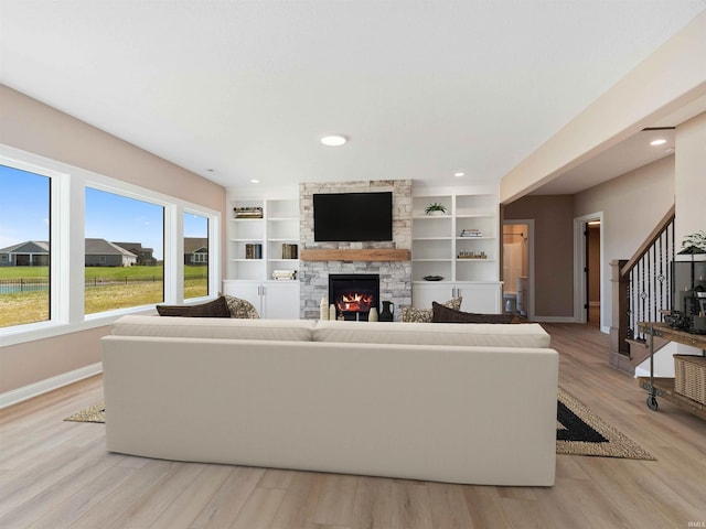 13092 Hallux Cv, Fort Wayne, IN 46845 - living area with stairs, light wood-style floors, a stone fireplace, recessed lighting, and built in features
