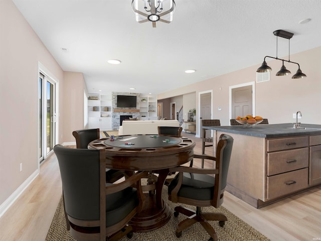13092 Hallux Cv, Fort Wayne, IN 46845 - dining room featuring light wood-style floors, a stone fireplace, and built in features