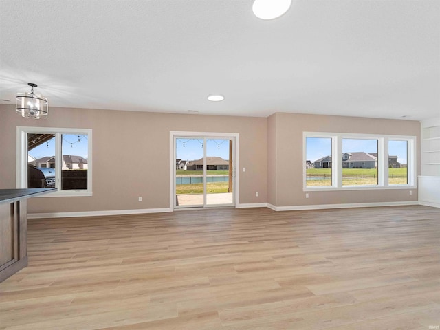 13092 Hallux Cv, Fort Wayne, IN 46845 - unfurnished living room with light wood-style flooring, a chandelier, and recessed lighting