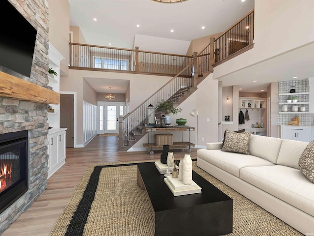13092 Hallux Cv, Fort Wayne, IN 46845 - living area with a high ceiling, stairway, a stone fireplace, light wood finished floors, and recessed lighting