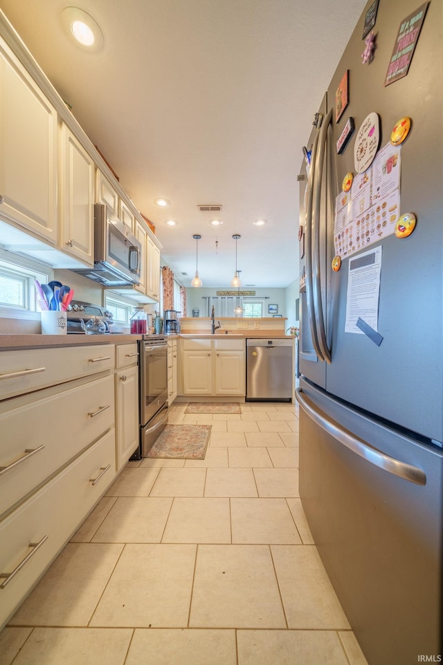 1510 W Crane Pond Dr, Marion, IN 46952 - kitchen featuring stainless steel appliances, a peninsula, decorative light fixtures, white cabinetry, and recessed lighting