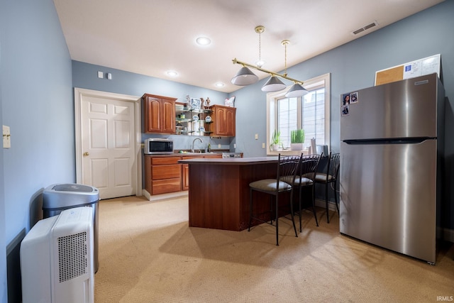 2220 Meadowbrook Dr, Marion, IN 46952 - kitchen with stainless steel appliances, light colored carpet, a peninsula, brown cabinetry, and recessed lighting