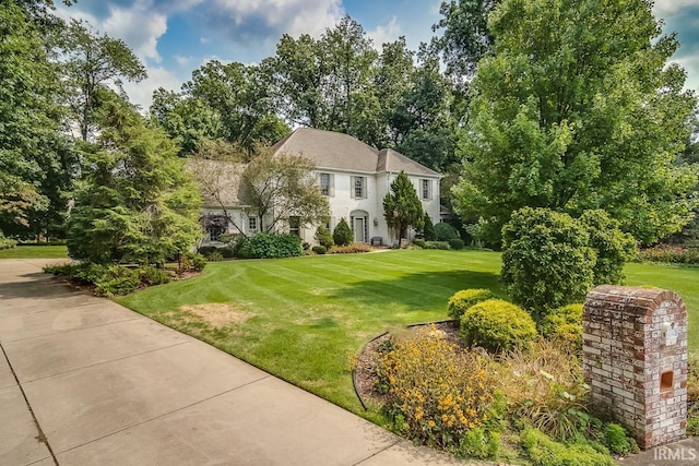 51310 Hidden Pines Ct, Granger, IN 46530 - colonial inspired home with a front lawn and view of scattered trees