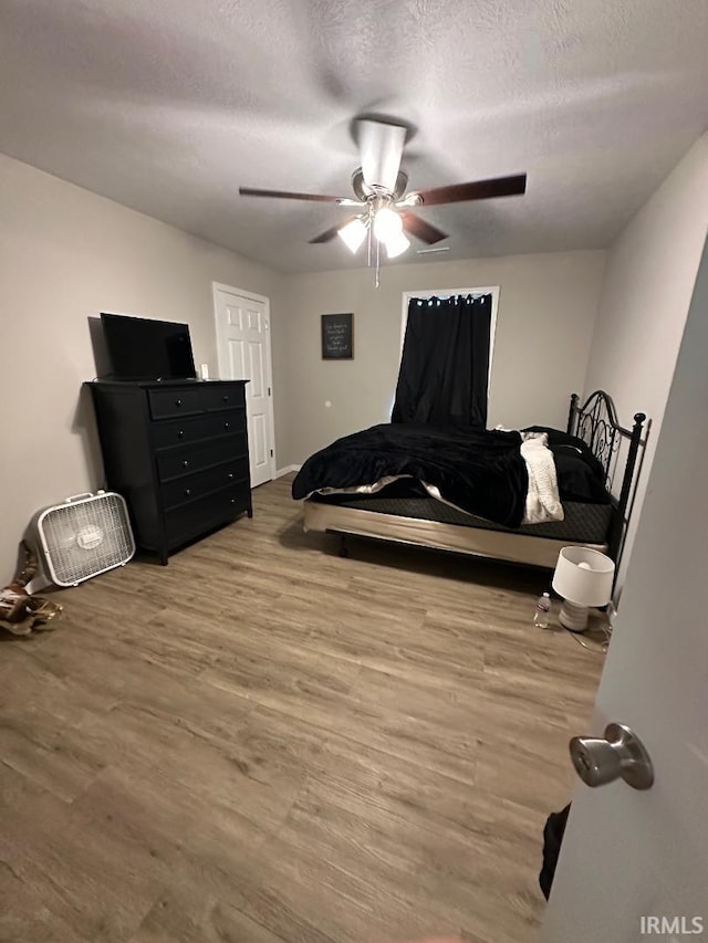 148 SW 8th St, Linton, IN 47441 - bedroom featuring wood finished floors, a textured ceiling, and a ceiling fan