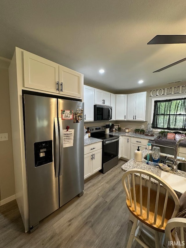 148 SW 8th St, Linton, IN 47441 - kitchen with stainless steel appliances, white cabinets, dark wood finished floors, recessed lighting, and light stone countertops