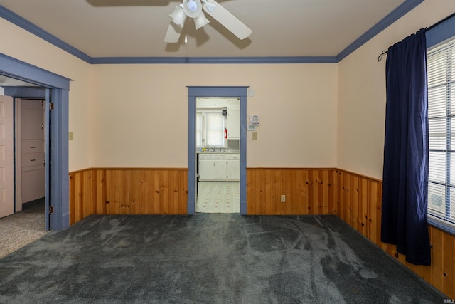 617 S Indiana Ave, Auburn, IN 46706 - empty room featuring a wainscoted wall, ceiling fan, plenty of natural light, wooden walls, and ornamental molding
