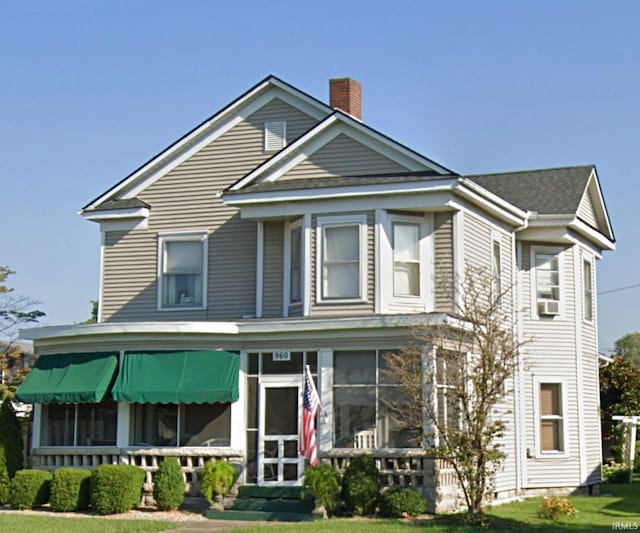 960 A St NE, Linton, IN 47441 - view of front of house featuring a sunroom, a chimney, a front lawn, and cooling unit