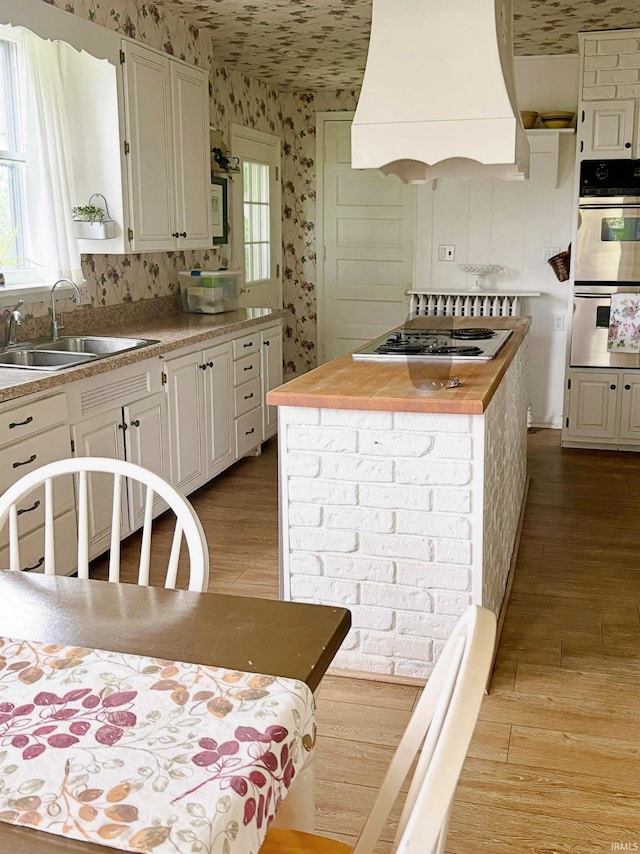 960 A St NE, Linton, IN 47441 - kitchen featuring electric cooktop, wallpapered walls, custom exhaust hood, light wood-type flooring, and wood counters
