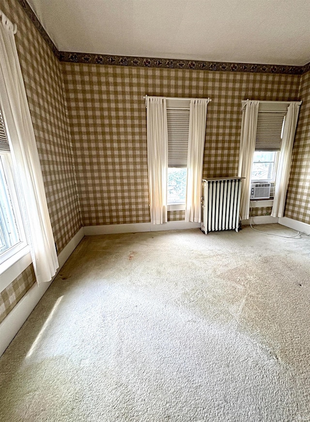 960 A St NE, Linton, IN 47441 - unfurnished room with wallpapered walls, radiator heating unit, carpet flooring, ornamental molding, and cooling unit
