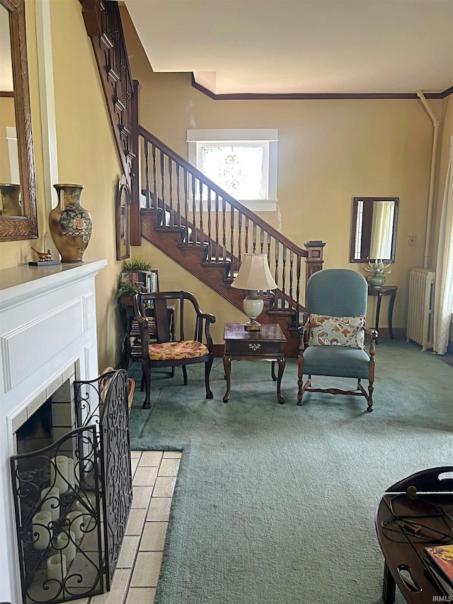 960 A St NE, Linton, IN 47441 - living area featuring radiator heating unit, light colored carpet, stairway, and a fireplace with flush hearth