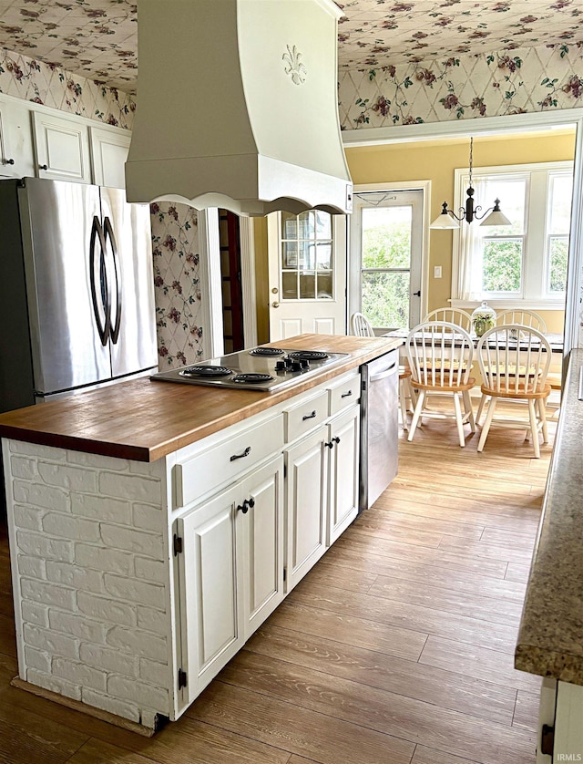 960 A St NE, Linton, IN 47441 - kitchen featuring butcher block counters, appliances with stainless steel finishes, custom exhaust hood, white cabinets, and wallpapered walls