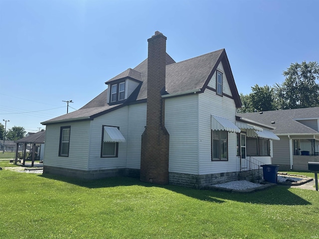 448 N 7th St, Mitchell, IN 47446 - view of home's exterior with a lawn, a chimney, and a shingled roof