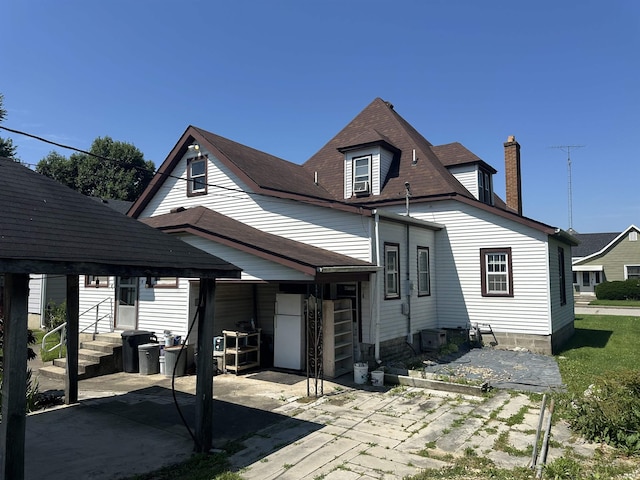 448 N 7th St, Mitchell, IN 47446 - rear view of house featuring entry steps, a patio, and a chimney
