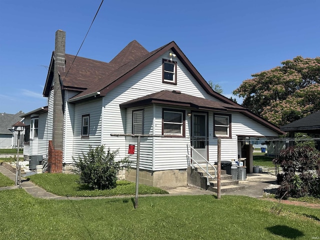 448 N 7th St, Mitchell, IN 47446 - view of front of house featuring entry steps, a front lawn, a chimney, and roof with shingles