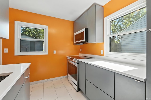 1914 Emerson Ave, Fort Wayne, IN 46808 - kitchen with stainless steel electric range, gray cabinetry, light countertops, and light tile patterned floors