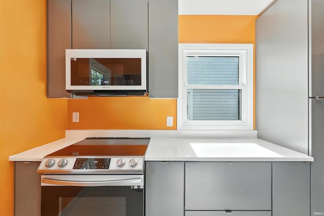1914 Emerson Ave, Fort Wayne, IN 46808 - kitchen featuring electric range, white microwave, gray cabinets, and light countertops