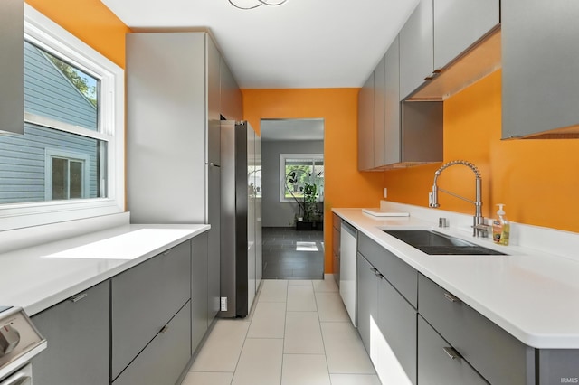 1914 Emerson Ave, Fort Wayne, IN 46808 - kitchen with gray cabinetry, freestanding refrigerator, dishwashing machine, light countertops, and light tile patterned flooring